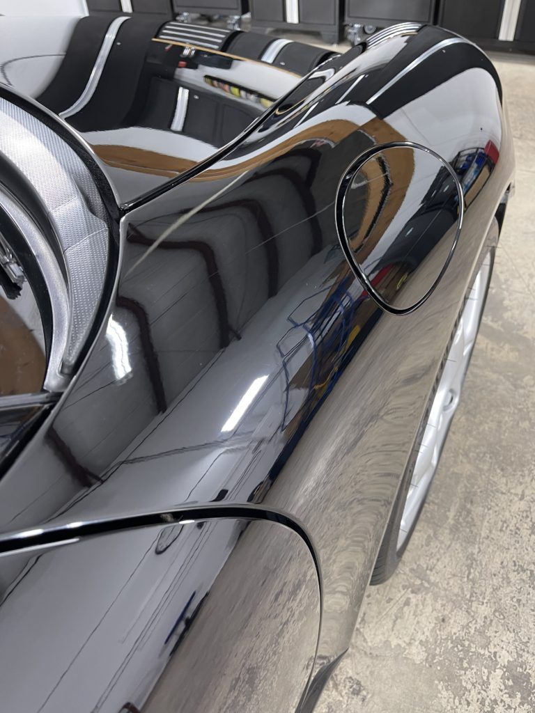 A black and white sports car is parked in a garage.