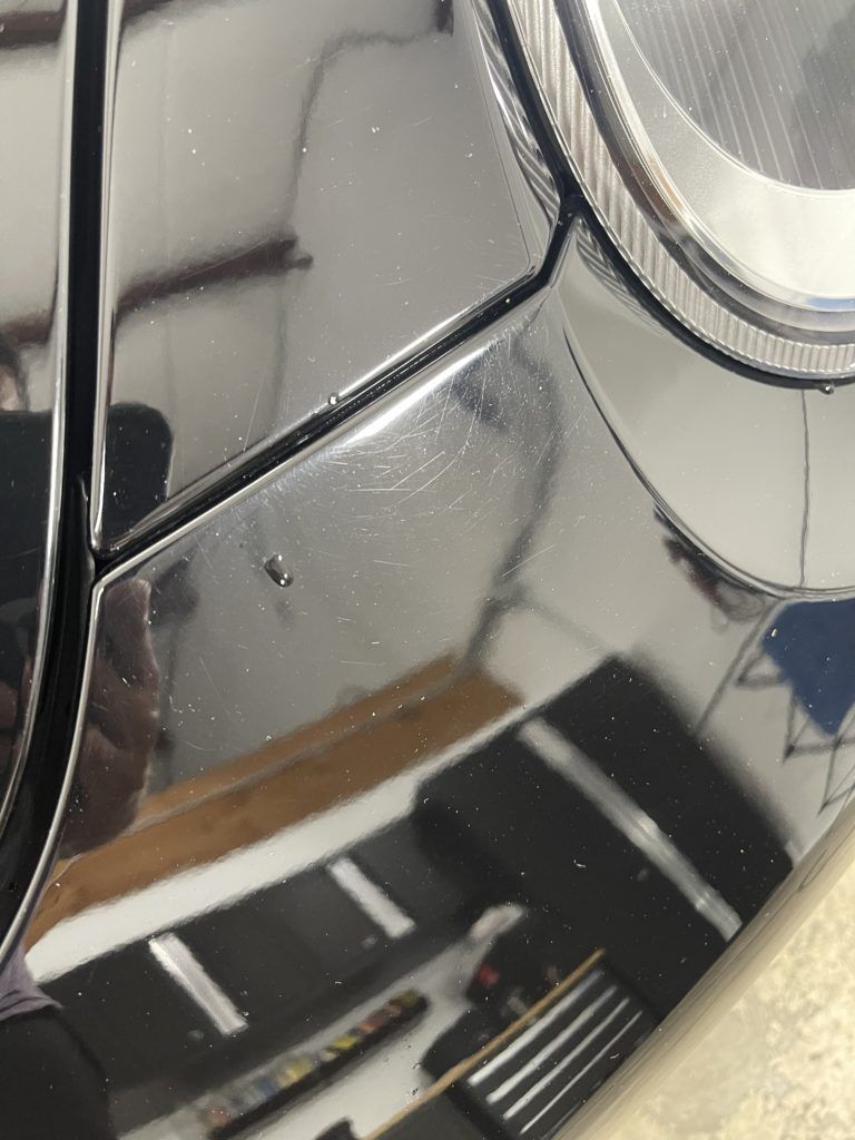 A close up of a car headlight in a garage.