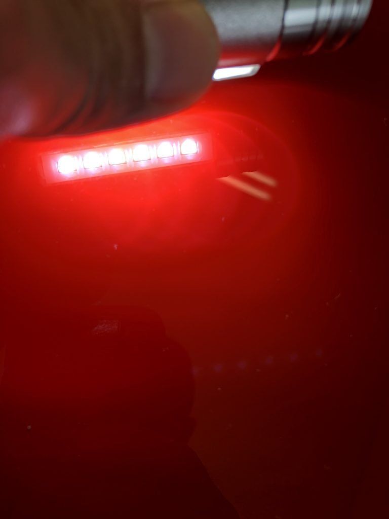 A close up of a red light bulb on a red surface.