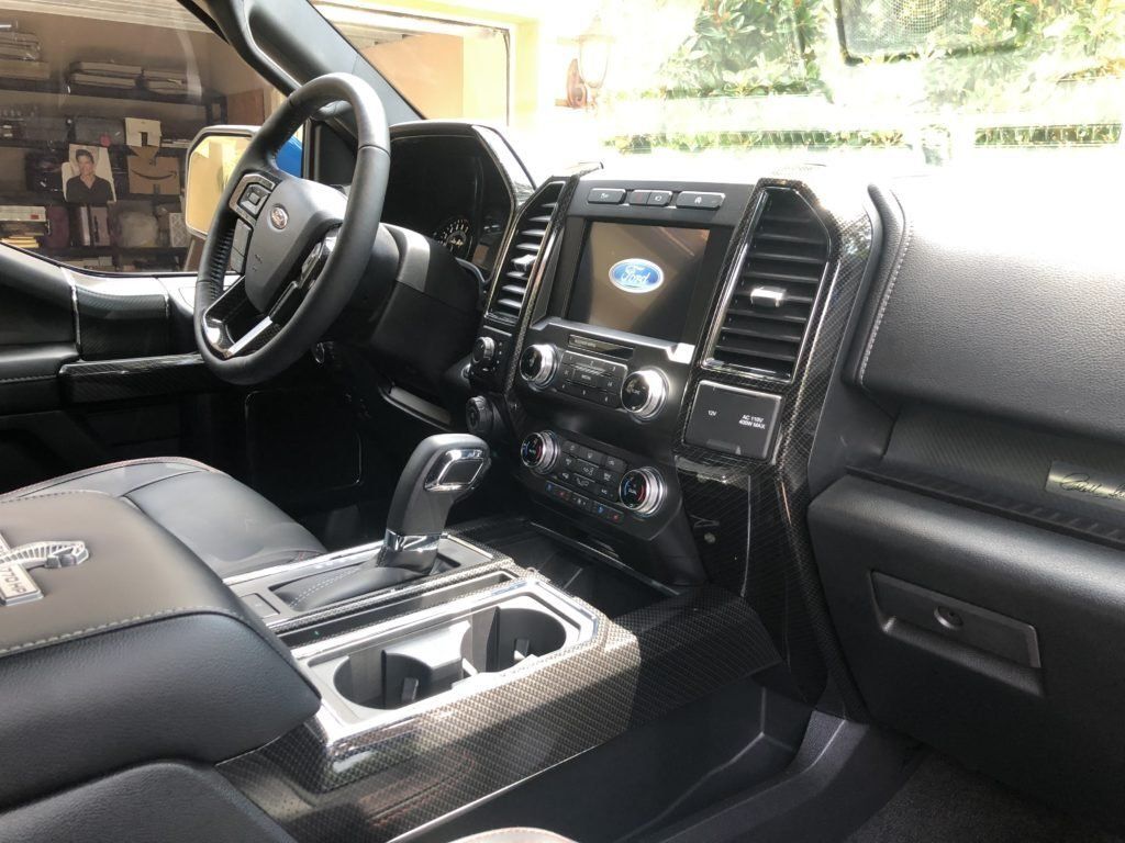 The interior of a ford f150 truck with a steering wheel and dashboard.