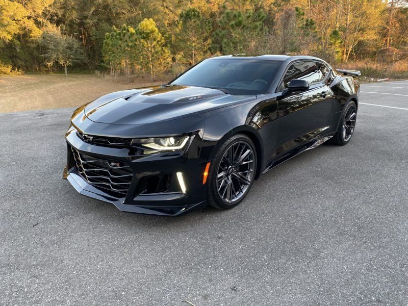 A black chevrolet camaro zl1 is parked in a parking lot.