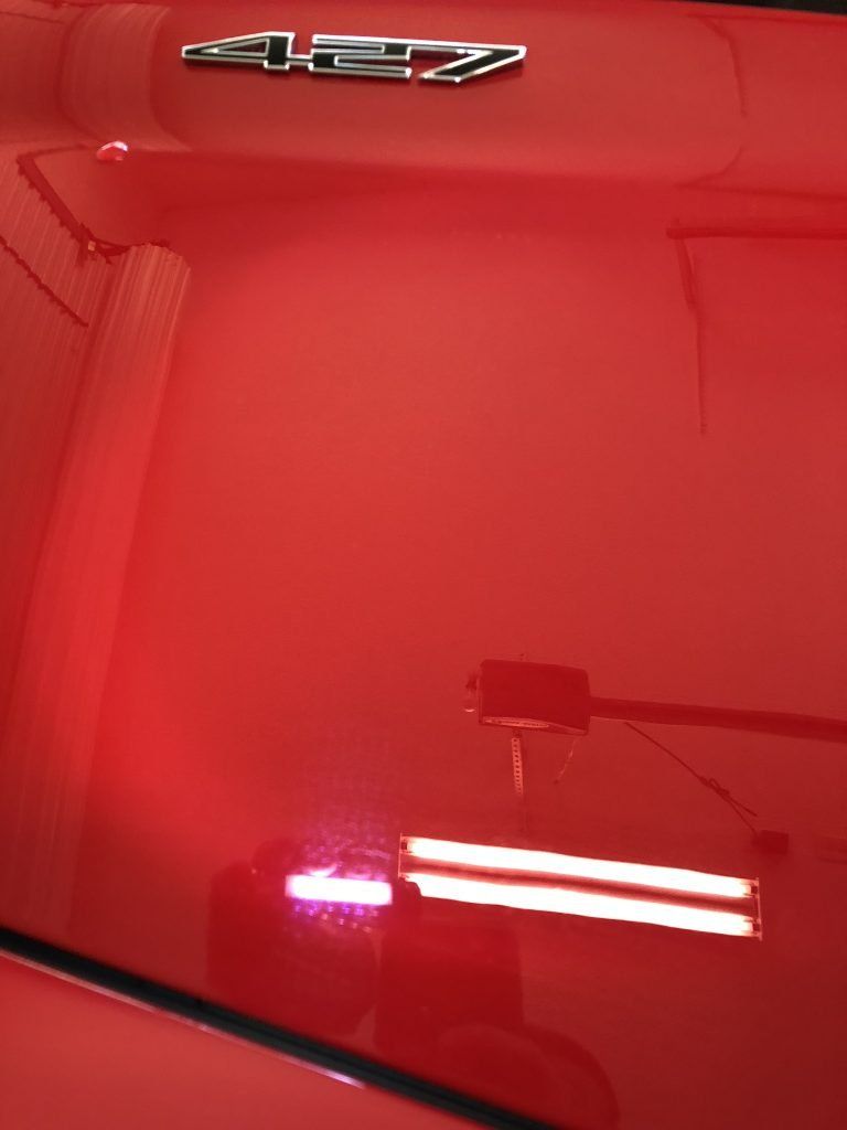 A red car with a chevrolet emblem on the hood