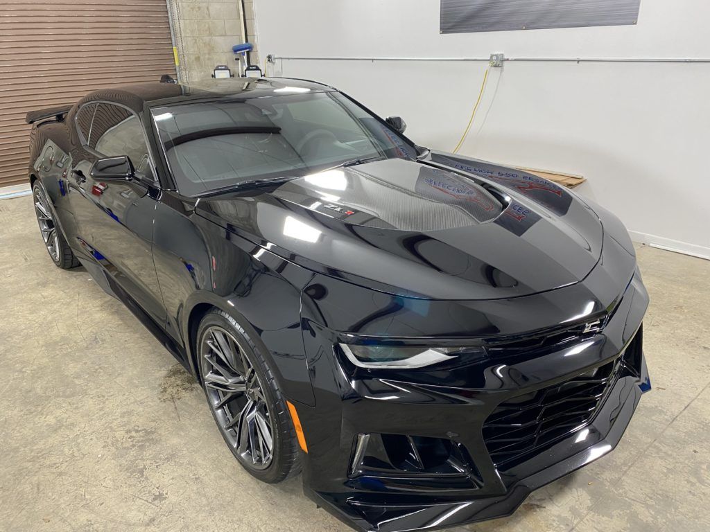 A black chevrolet camaro zl1 is parked in a garage.