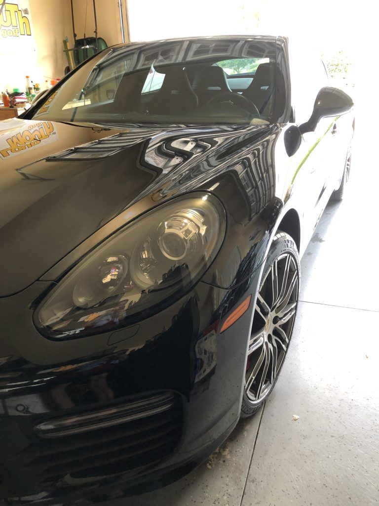 A black sports car is parked in a garage.