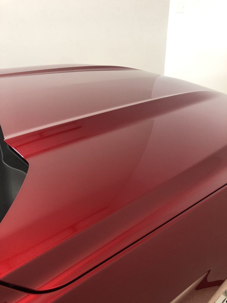 A close up of the hood of a red car