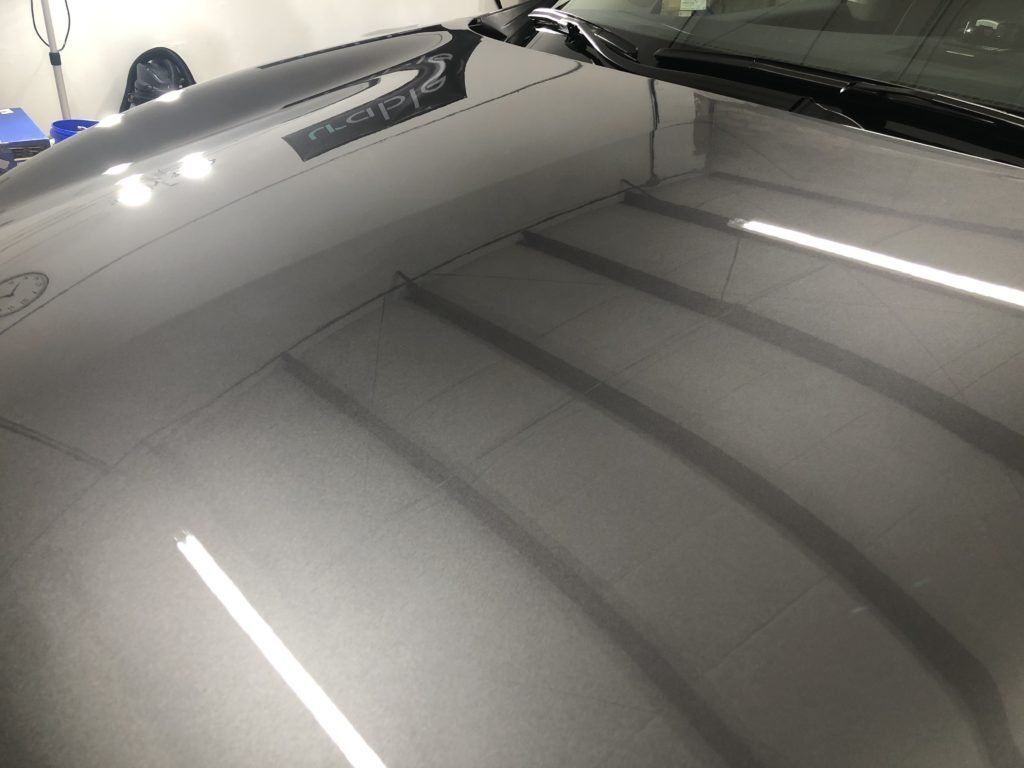 A close up of the hood of a car in a garage.