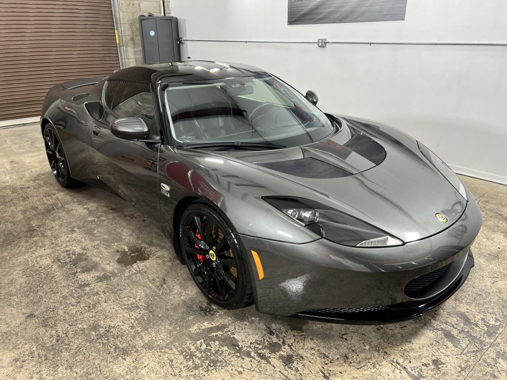 A gray sports car is parked in a garage.