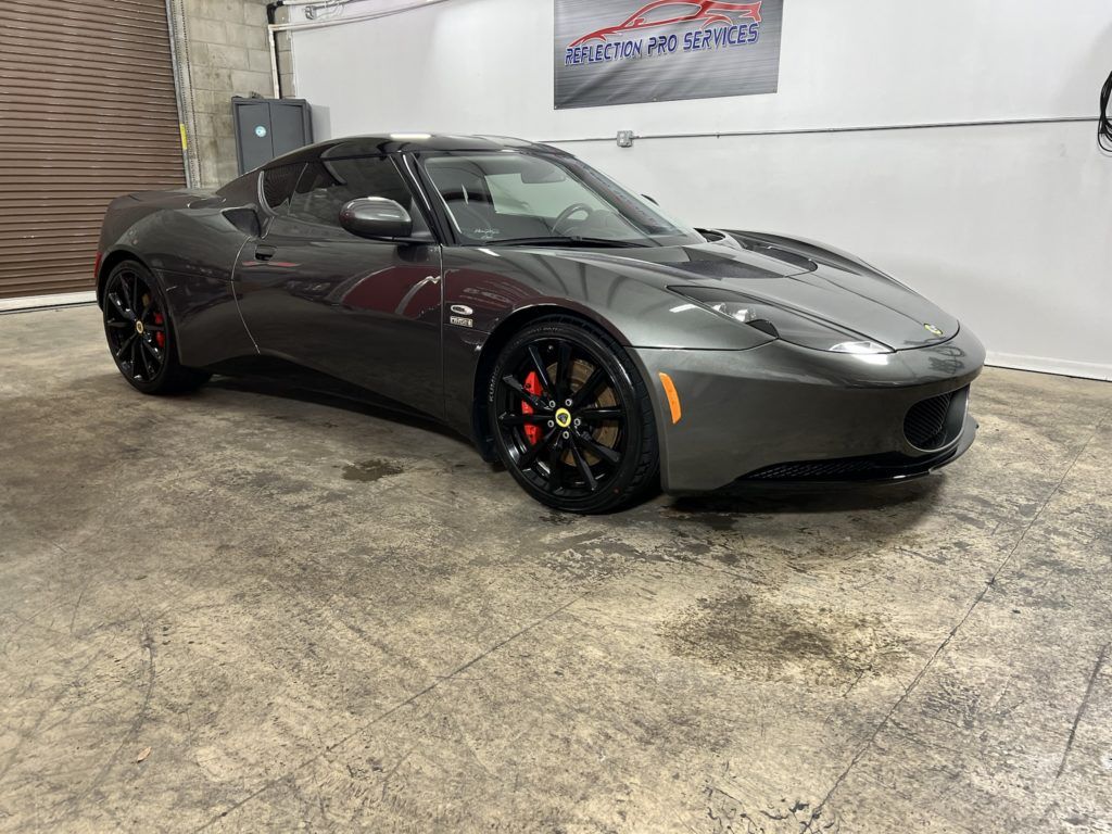 A gray sports car is parked in a garage.