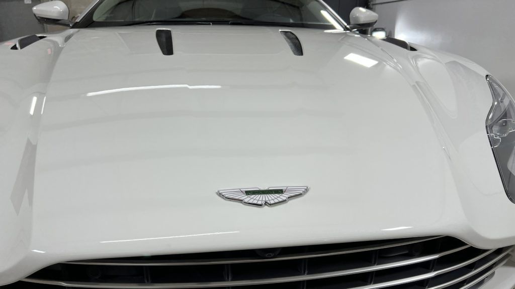 A white aston martin sports car is parked in a garage.