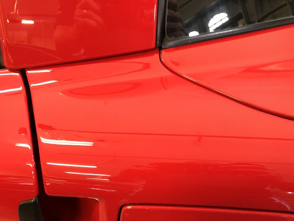 A close up of the side of a red car