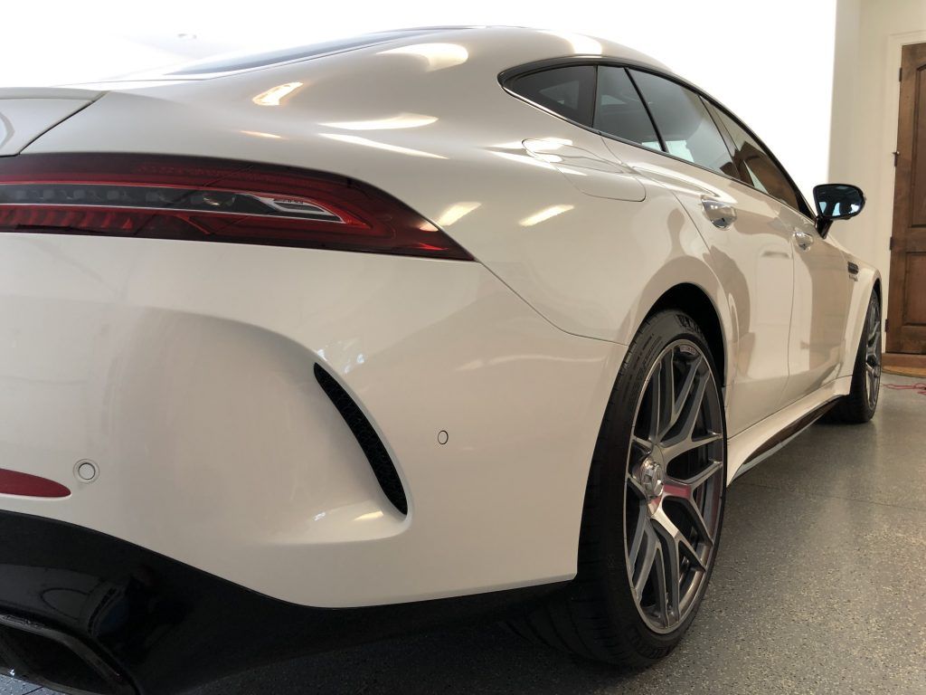 A white sports car is parked in a garage.
