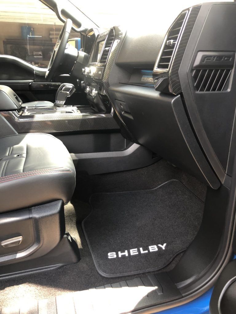 The interior of a shelby truck with a black mat on the floor.