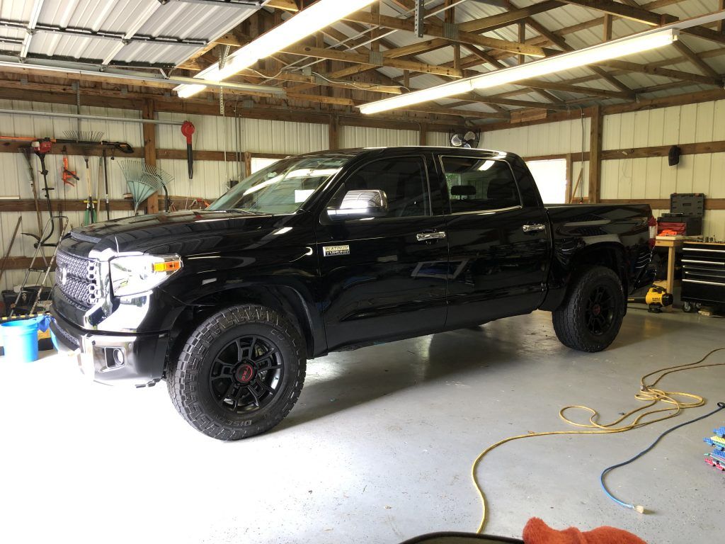 A black truck is parked in a garage.