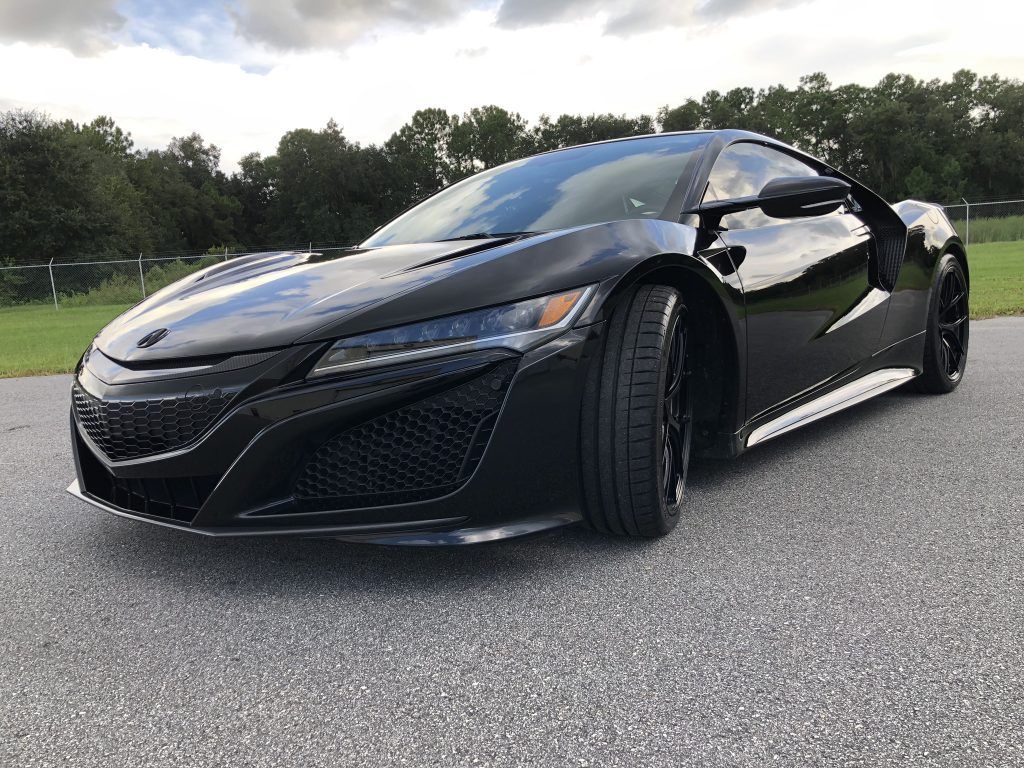 A black sports car is parked on the side of the road.
