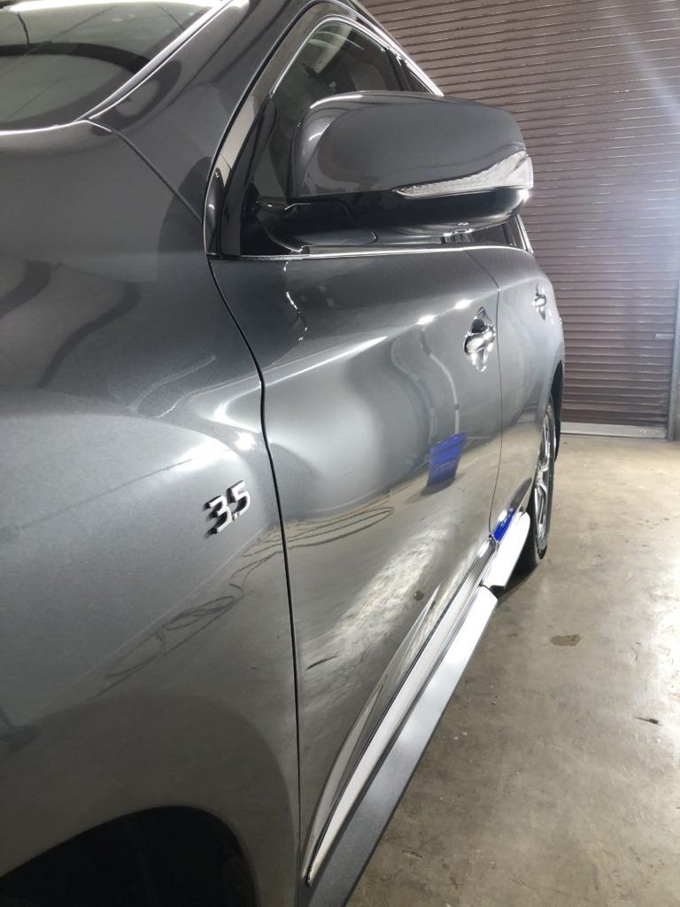 A silver car is parked in front of a garage door