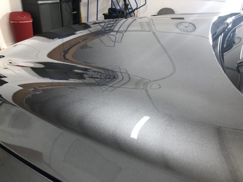 A close up of the hood of a car in a garage.