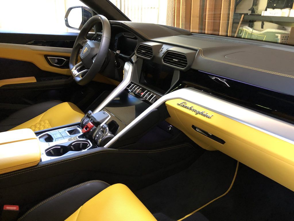 The interior of a lamborghini urus is yellow and black.