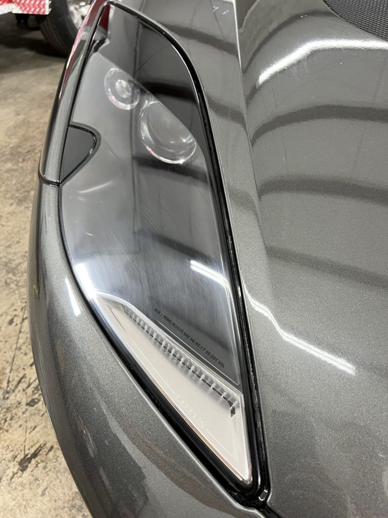 A close up of a car 's headlight in a garage.
