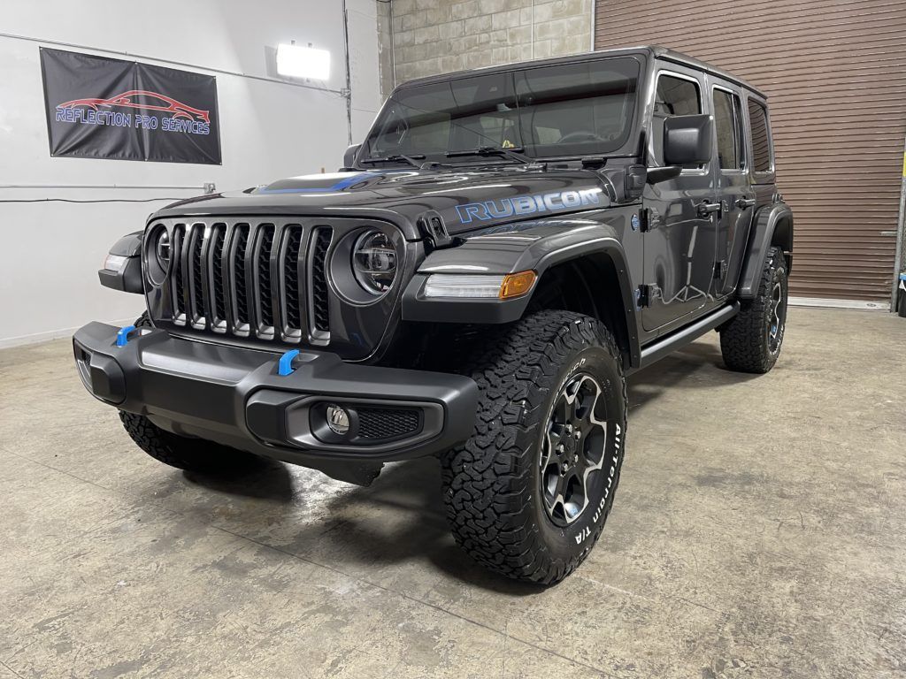 A black jeep wrangler is parked in a garage.