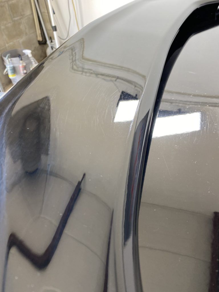A close up of a car hood in a garage.