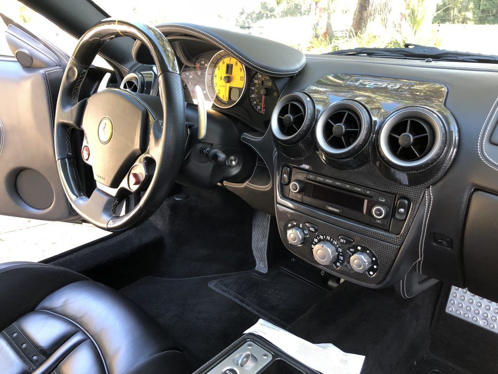 The interior of a ferrari sports car with a steering wheel and dashboard.