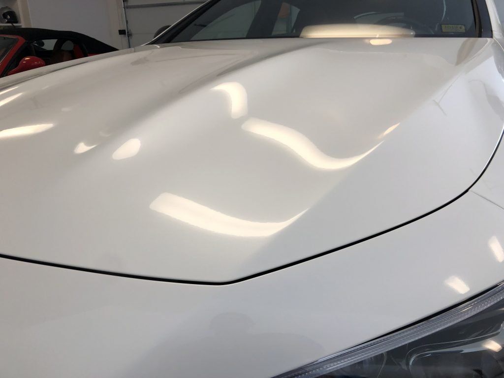A close up of the hood of a white car