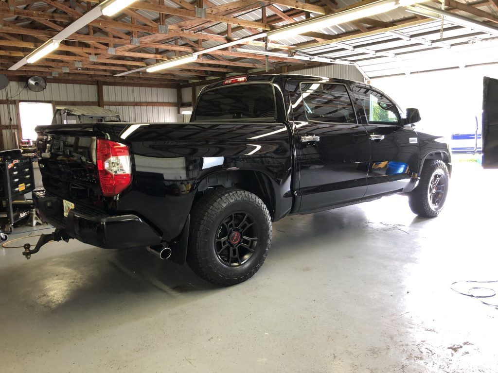 A black toyota tundra is parked in a garage.