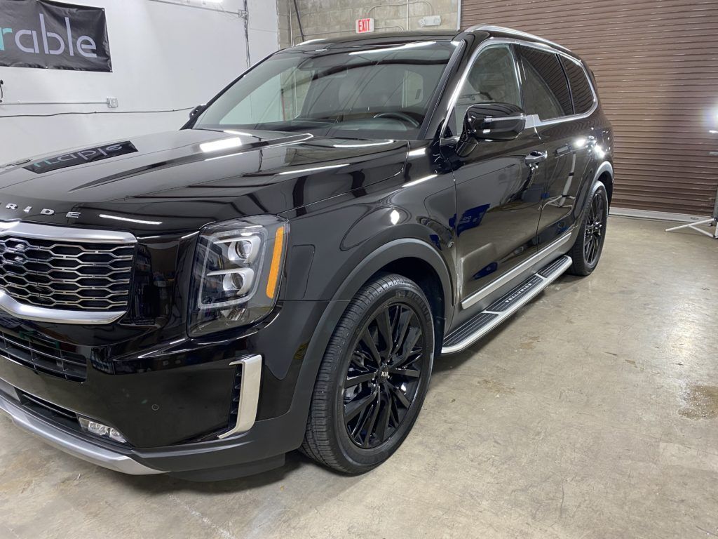 A black suv is parked in a garage.