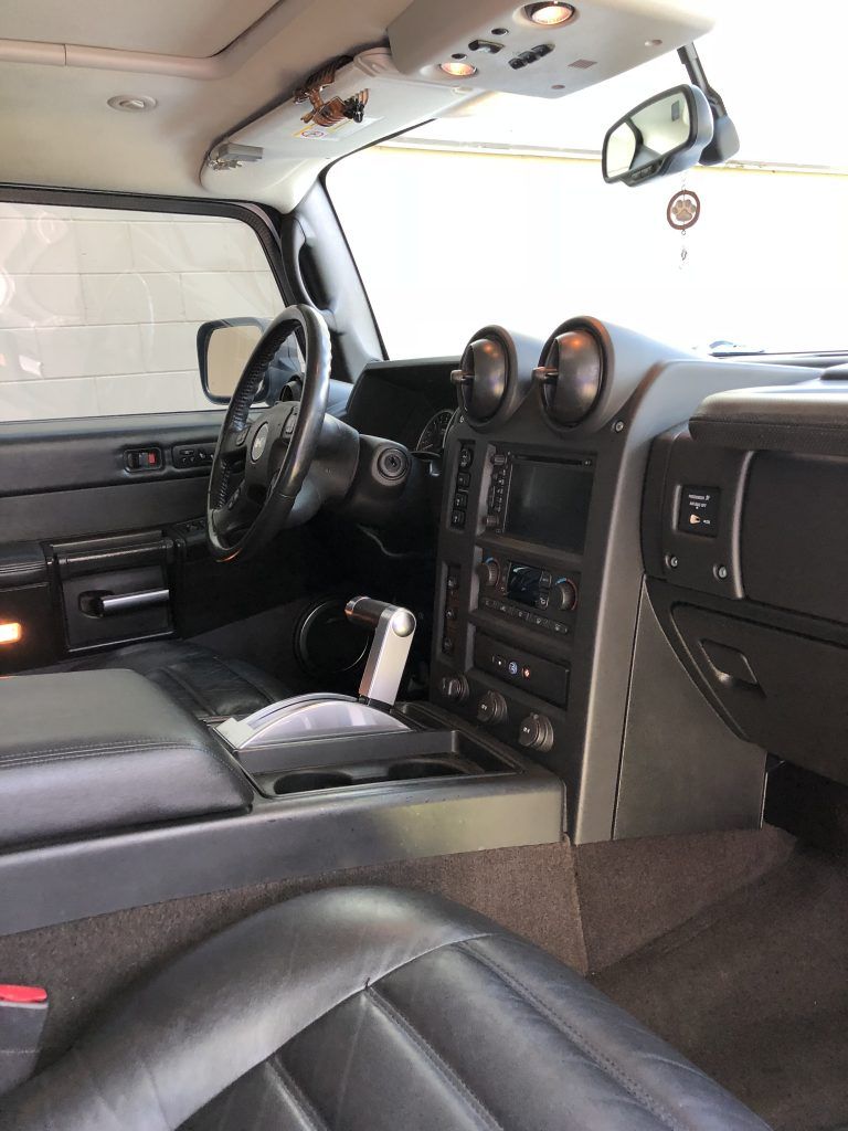 The interior of a hummer h2 is shown with a steering wheel and dashboard.