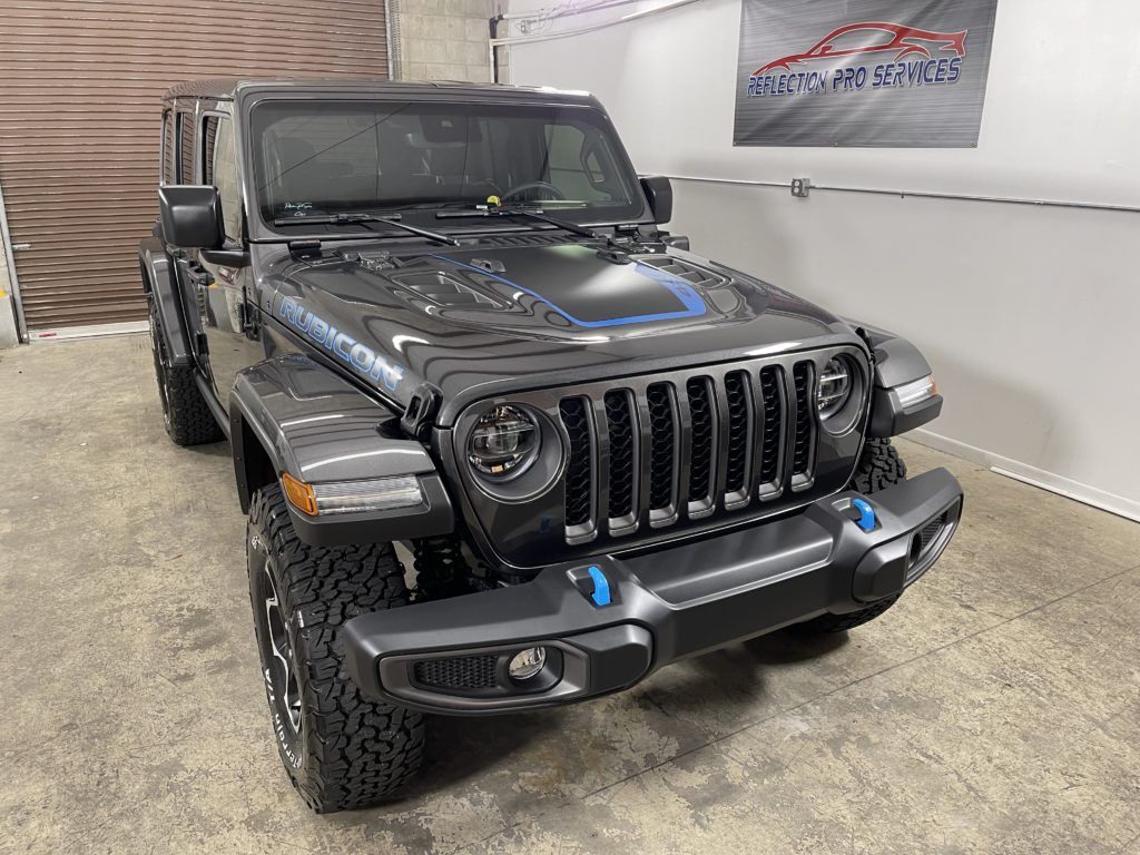 A black jeep wrangler is parked in a garage.