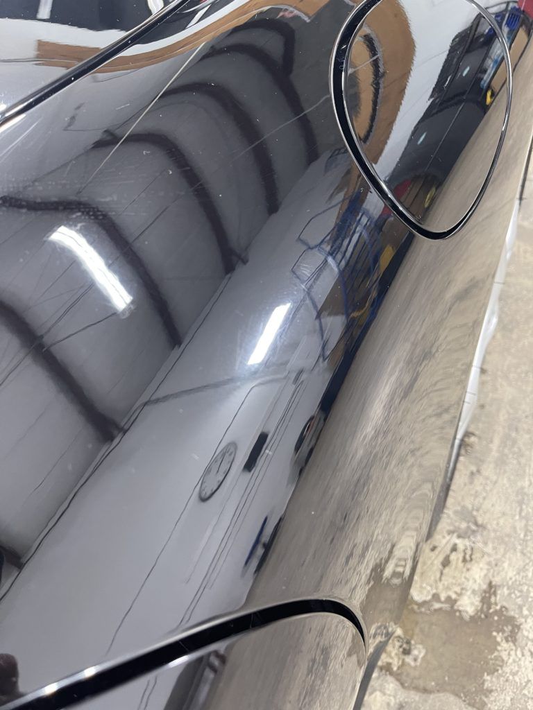 A close up of a car with a reflection in the mirror.