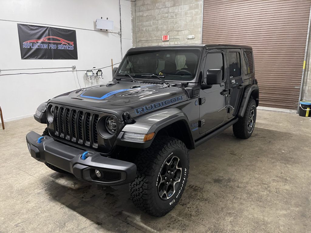 A black jeep wrangler is parked in a garage.