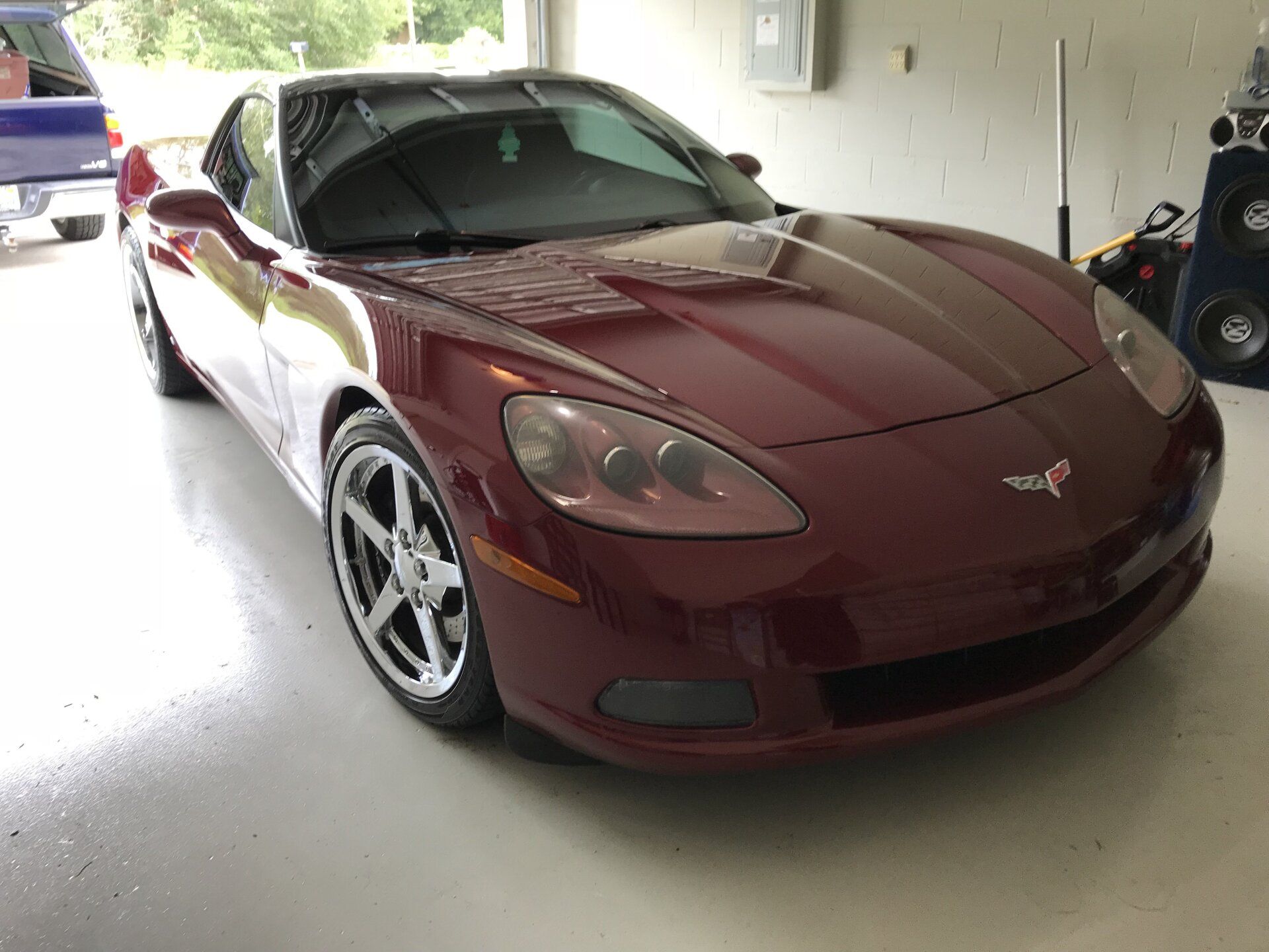 A red sports car is parked in a garage