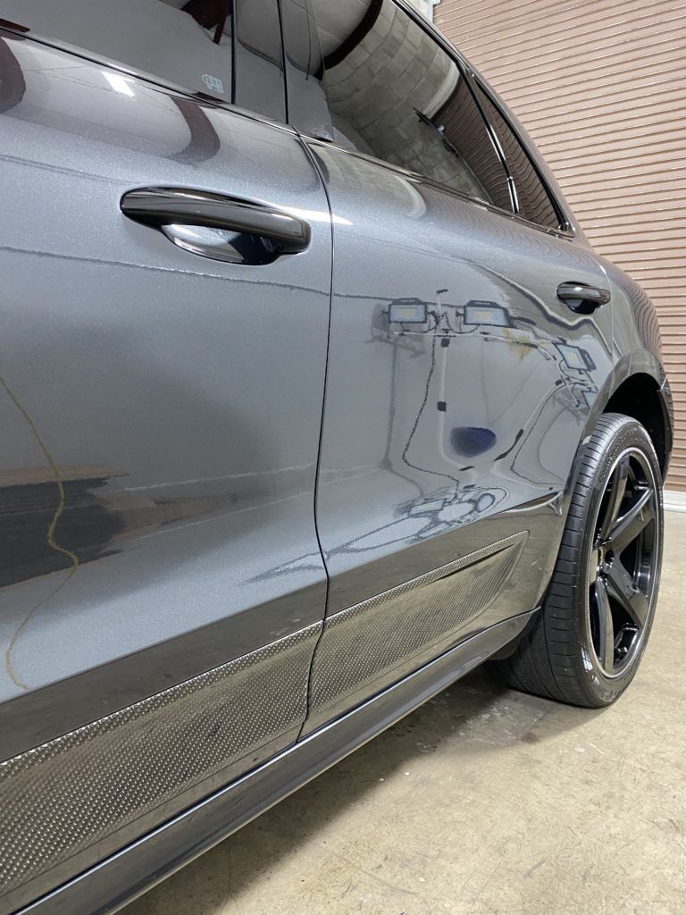 A close up of a black car parked in a garage.
