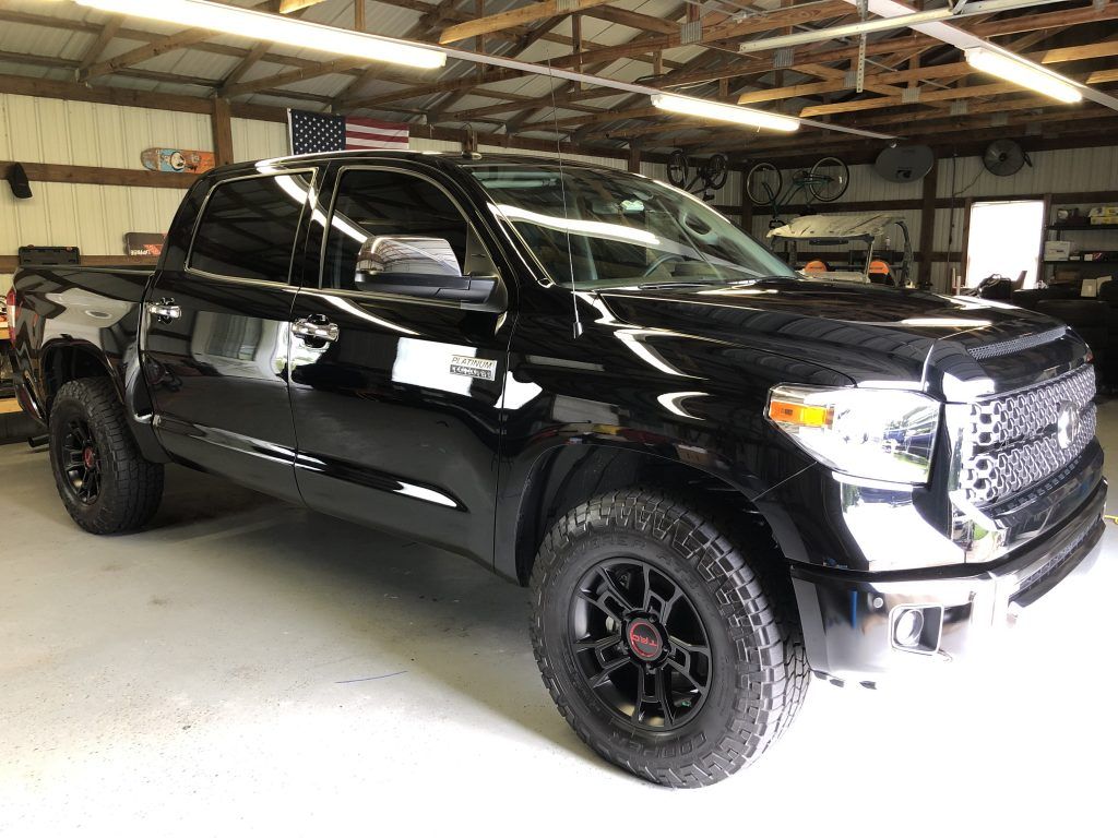 A black toyota tundra is parked in a garage.