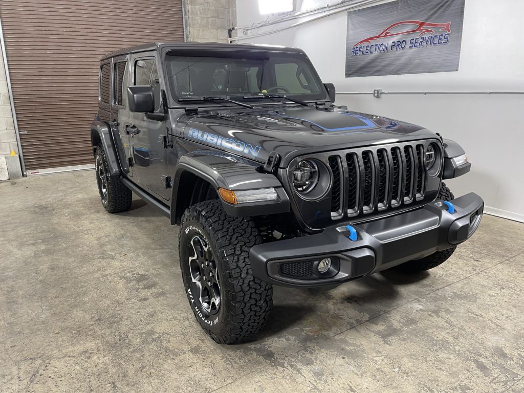 A jeep wrangler is parked in a garage next to a garage door.
