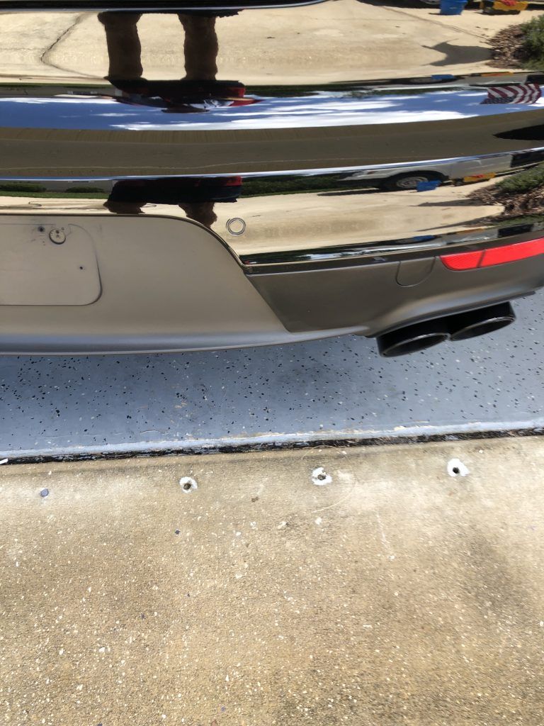 A black car is parked on the side of the road.
