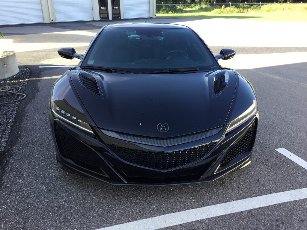 A black sports car is parked in a parking lot.