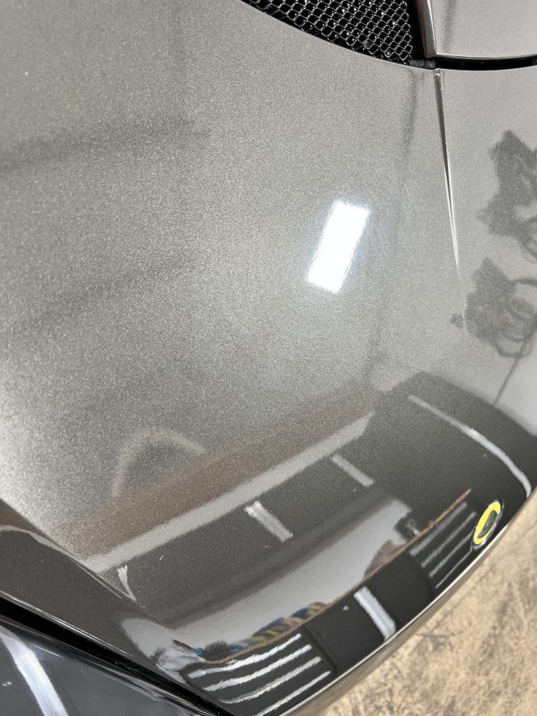 A close up of the hood of a car in a garage.