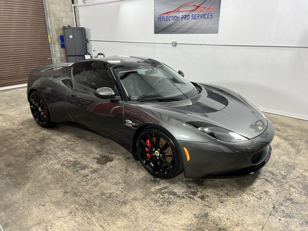 A gray sports car is parked in a garage.