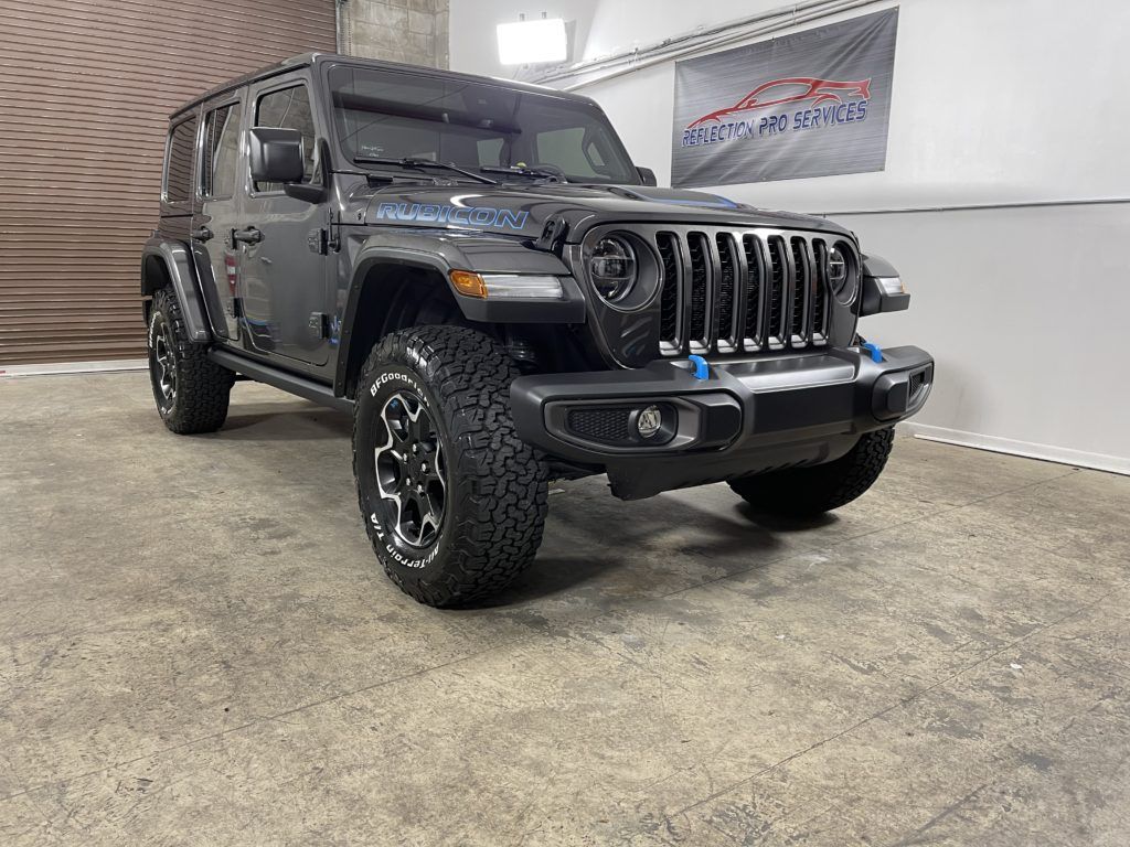 A black jeep wrangler is parked in a garage.