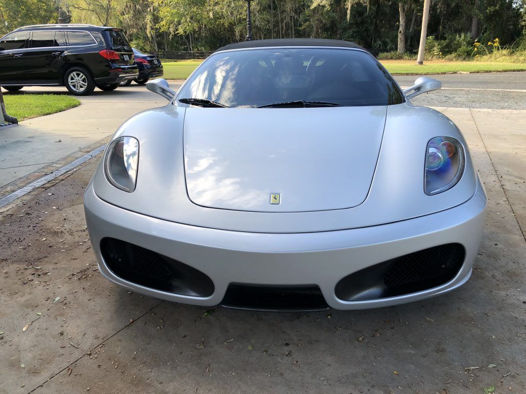 A silver sports car is parked in a driveway.
