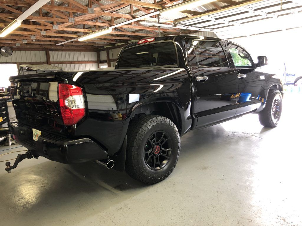A black toyota tundra is parked in a garage.