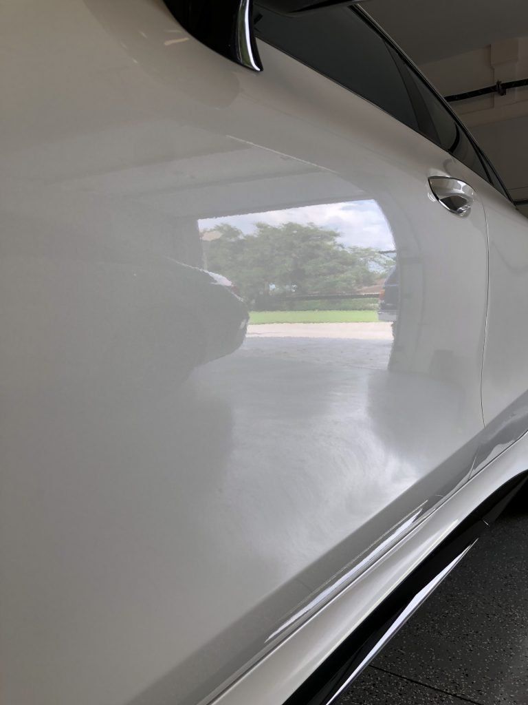 A close up of a white car parked in a garage.