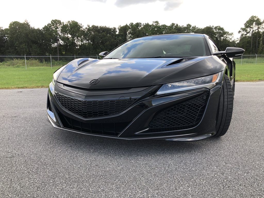A black sports car is parked on the side of the road.