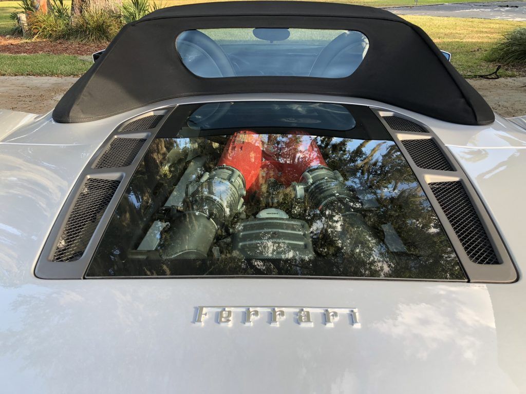 The engine of a ferrari sports car is visible through the windshield.