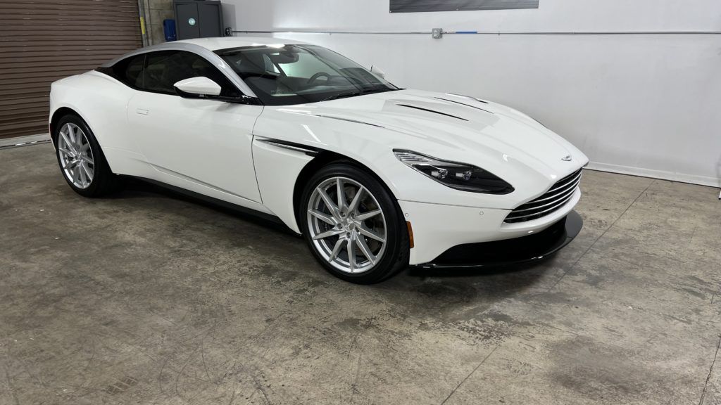 A white sports car is parked in a garage.