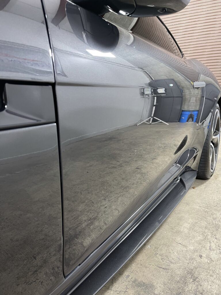 A close up of a black car parked in a garage.