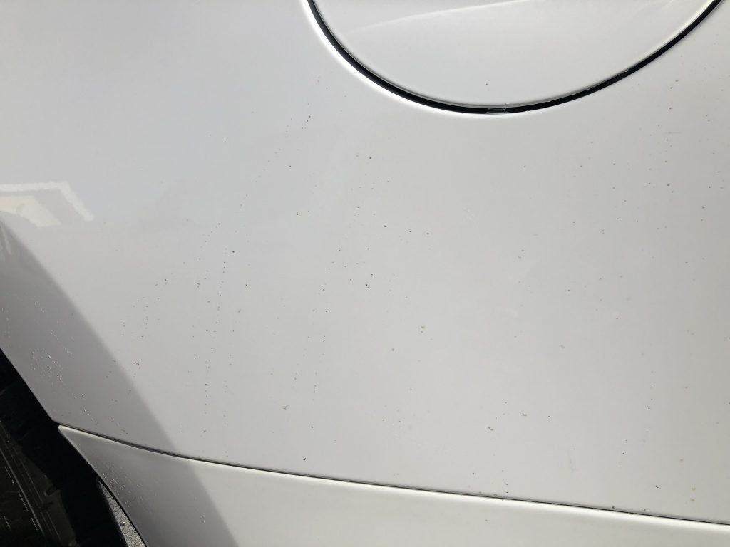 A close up of a white car with a fuel cap