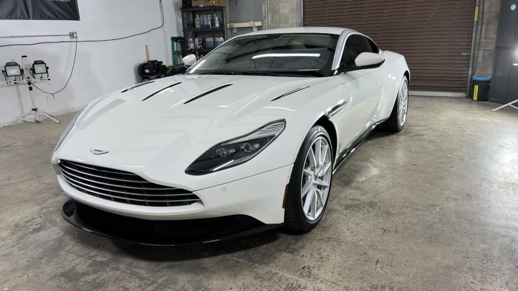 A white sports car is parked in a garage.